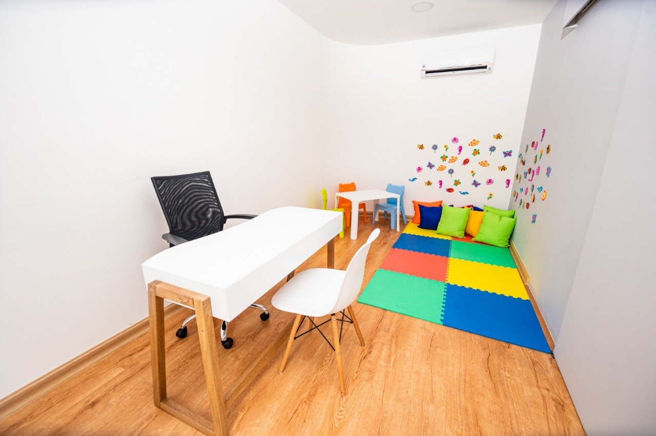 Consultorio infantil con mesa, sillas y alfombra de colores