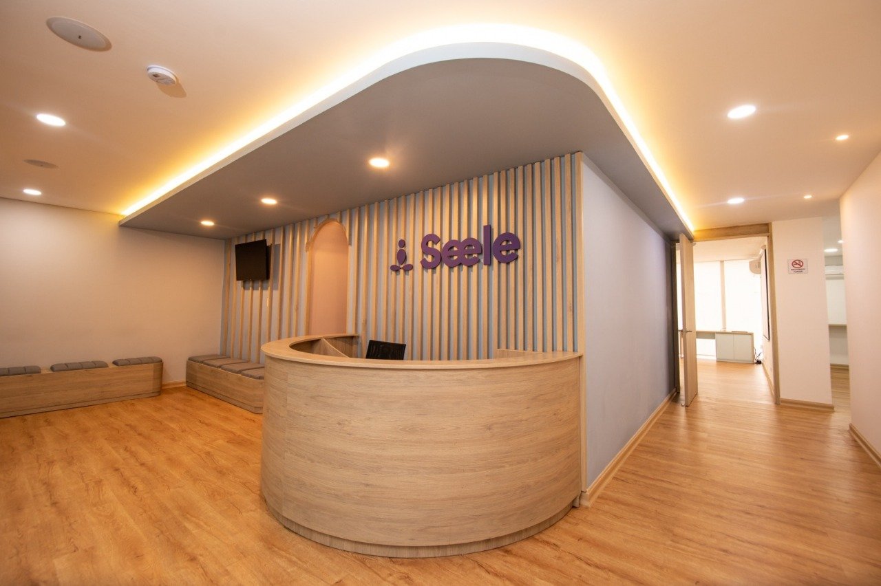 Recepción del centro con mostrador de madera y sala de espera